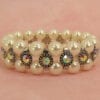 pearl bracelet with rainbow-colored gems on a pink surface