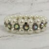 pearl bracelet with rainbow-colored gems on a marble surface