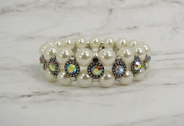 pearl bracelet with rainbow-colored gems on a marble surface