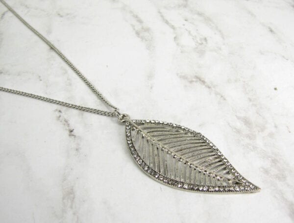 necklace with silver leaf design on a marble surface