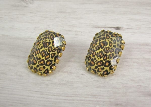 square earrings with animal print design on a wooden surface