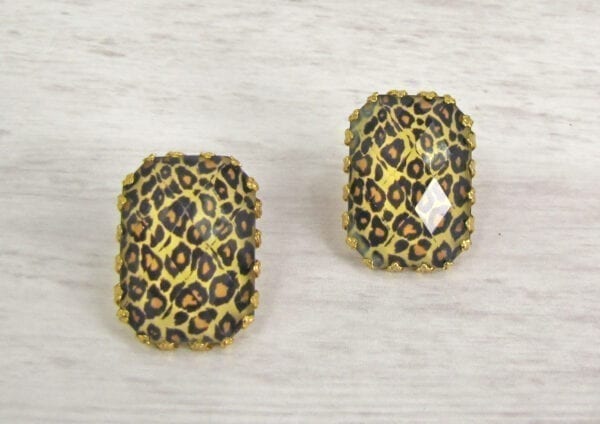top view of square earrings with animal print design on a wooden surface