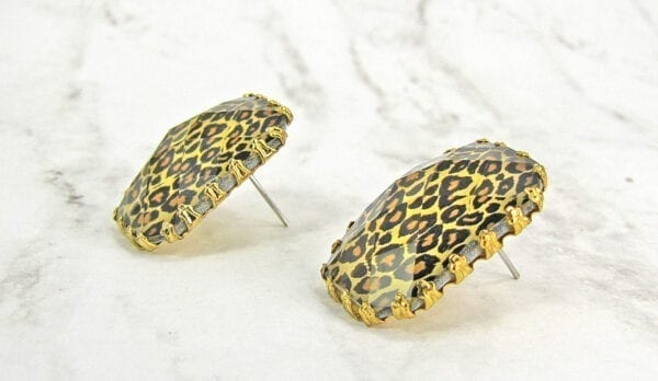 side view of square earrings with animal print design on a marble surface