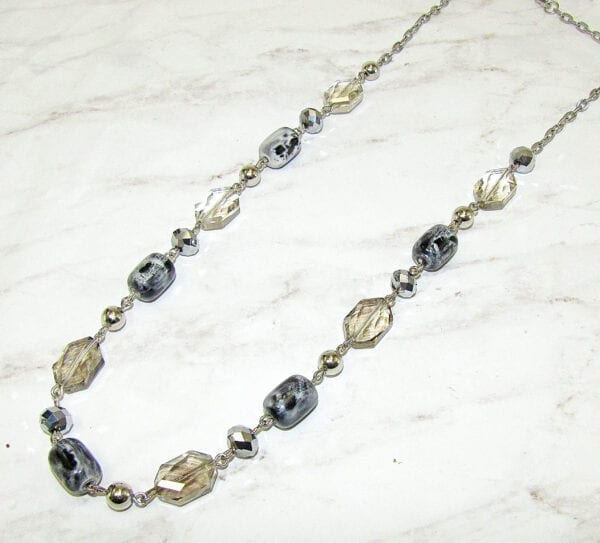 necklace with light yellow stones and silver beads on marble
