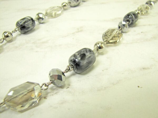 necklace with light yellow stones and silver beads on a marble surface
