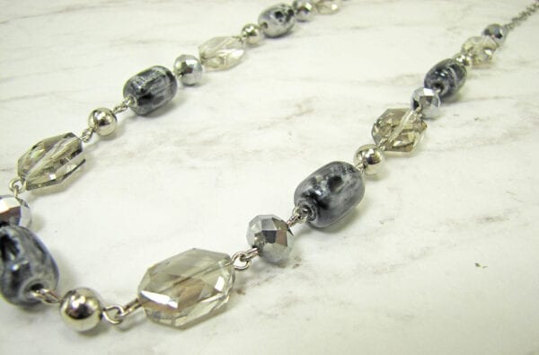 necklace with light yellow stones and silver beadwork on a marble surface