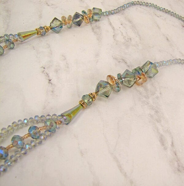 layered necklace with multicolored beads on a marble surface