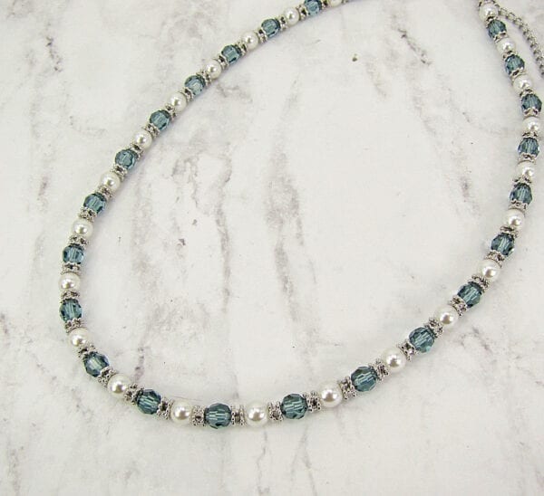 necklace with pearls and blue beadwork on a marble surface