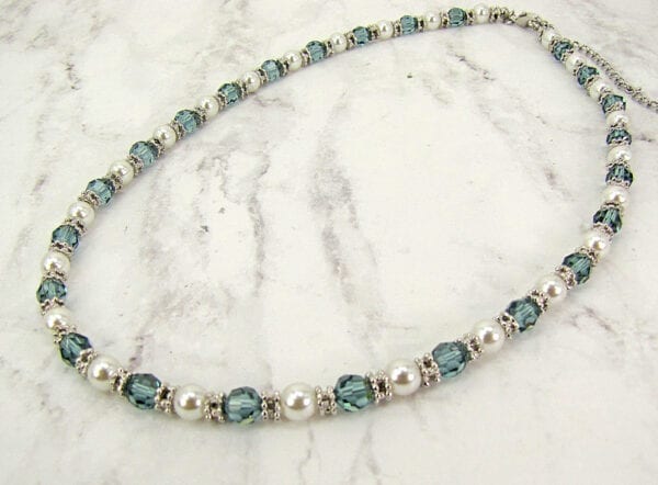 necklace with pearls and blue beads on a marble surface