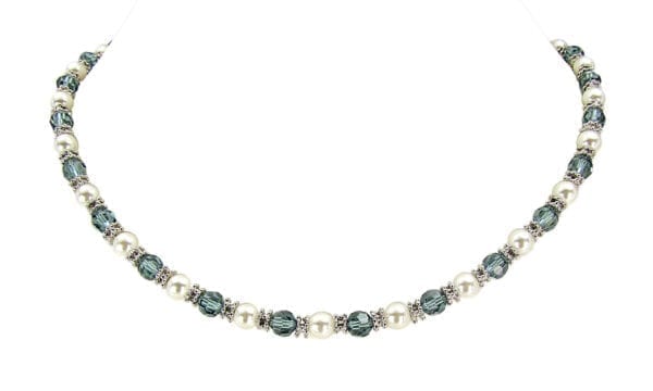 necklace with pearls and blue crystals displayed on a marble surface