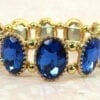 golden bracelet with sapphire gems on a cloth surface