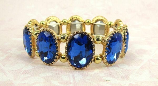 golden bracelet with sapphire gems on a cloth surface
