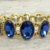 golden bracelet with sapphire gems on a wooden surface
