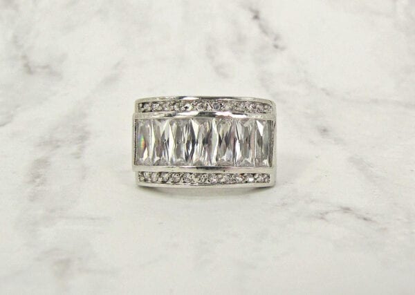 front view of a ring with rows of white rectangular crystals on marble surface