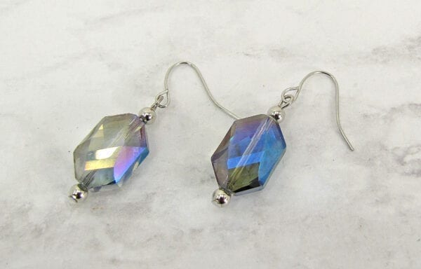 earrings with hexagonal blue crystals on a marble surface