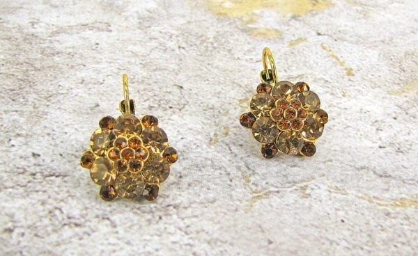 earrings with brown gems arranged like flowers on a concrete surface
