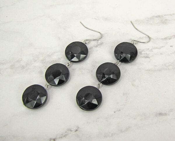 earrings with columns of black crystals on a marble surface