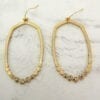 pair of earrings with rows of small beads on a marble surface