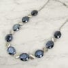necklace with black crystals and metallic beadwork on a marble surface
