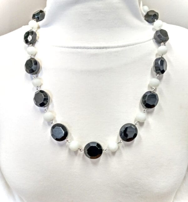 necklace with black crystal beads and pearls on a crumpled paper surface
