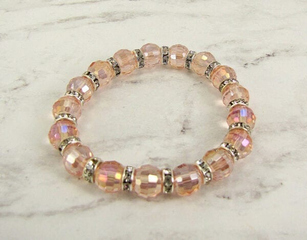bracelet with pink crystals and silver beads on a marble surface
