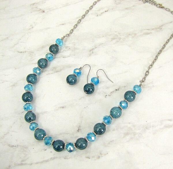 necklace with blue stones and crystals on a marble surface