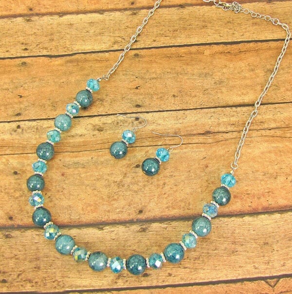 necklace and earrings with blue stones and crystals on a wooden surface