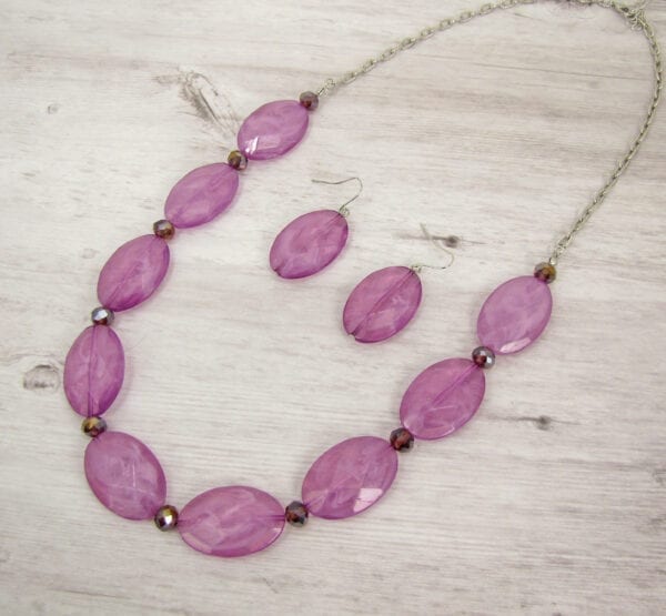 necklace with large oval violet beads on a wooden surface