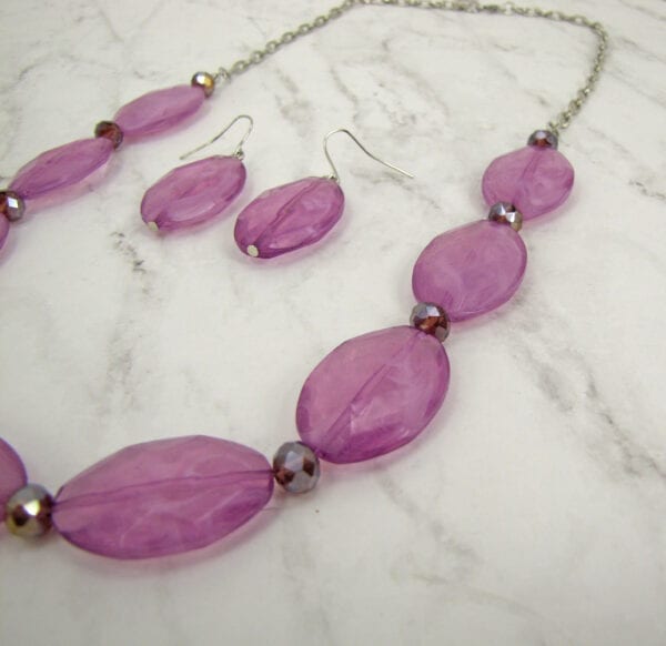 necklace with large oval violet beads on a marble surface