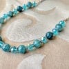 necklace with blue stones and crystals on a cloth surface