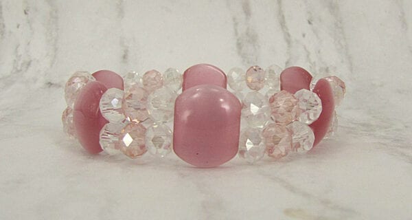 bracelet with pink stones and crystals on a marble surface
