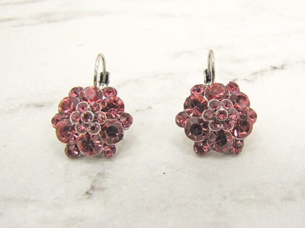 earrings with ruby gems arranged like flowers on a marble surface