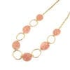 golden necklace with large metal hoops and pink beads