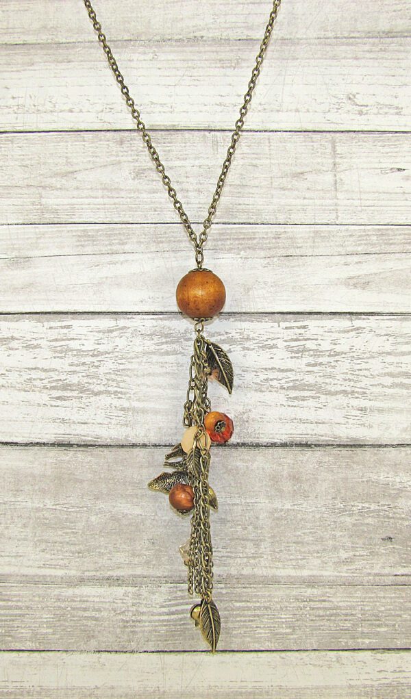 necklace with wooden pendant and assorted attachments on a wooden surface