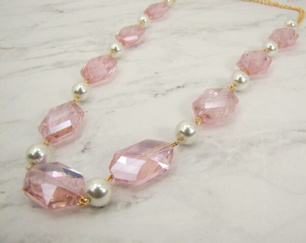 necklace with large, pink crystal gems on a marble surface