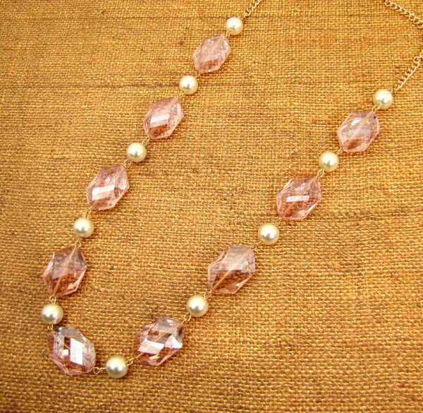 necklace with large, pink crystal gems on a brown fabric surface