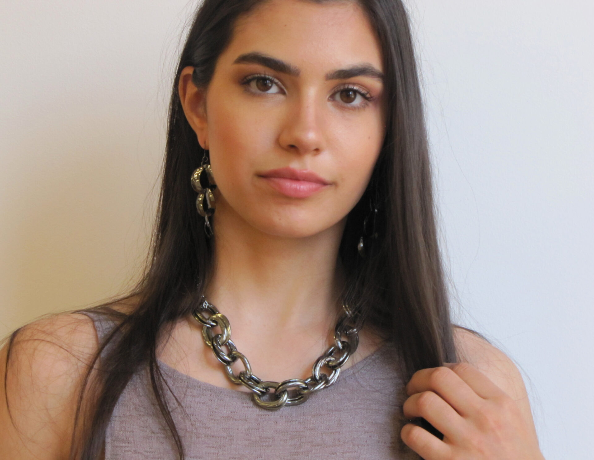 A woman in grey tops wearing a necklace