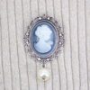 A Brooch With a Woman White Figure With a Pearl on a Cloth