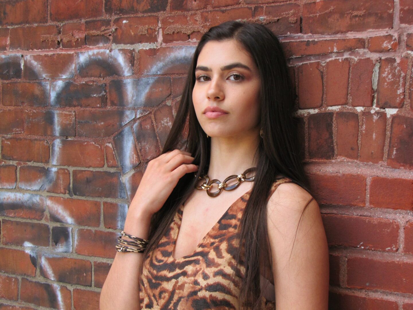 A woman in leopard striped tops wearing a necklace